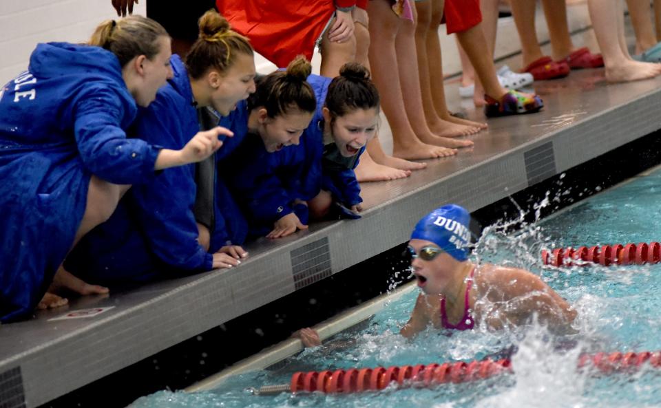 Dundee swimmers yell encouragement to teammate Joslyn Ball of Dundee in the butterfly at the Monroe County Swim Finals Saturday. Ball took second.