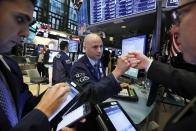 Specialist Mario Picone, center, works with traders at his post on the floor of the New York Stock Exchange, Friday, Nov. 9, 2018. Stocks are falling as energy companies are dragged lower by the continuing plunge in crude oil prices. (AP Photo/Richard Drew)
