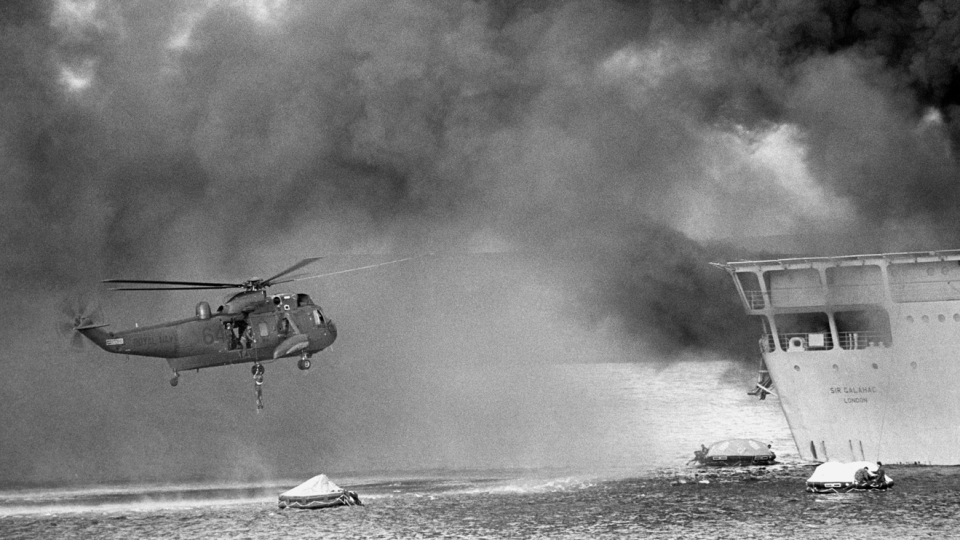 Helicopters attempt to rescue survivors from the Sir Galahad 