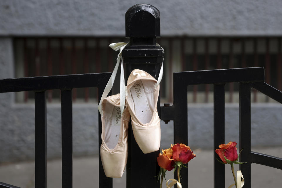 Ballet shoes are seen hanging on the fence of the Vladislav Ribnikar school in Belgrade, Serbia, Thursday, May 4, 2023. Police say a 13-year-old who opened fire at his school drew sketches of classrooms and made a list of people he intended to target. He killed eight fellow students and a school guard before being arrested. (AP Photo/Armin Durgut)