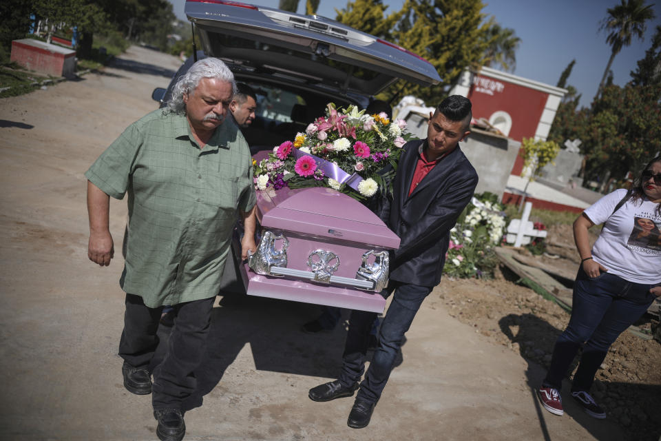 The casket of slain Marbella Valdez is carried by her ex-boyfriend Jairo Solano, right, from the hearse to her grave in Tijuana, Mexico, Friday, Feb. 14, 2020. When the law student’s body was found at a garbage dump in Tijuana, the man who was obsessed with her, another man named Juan, demanded police solve the case, attended her funeral, and a week later was arrested and charged with her murder. Juan has insisted on his innocence. (AP Photo/Emilio Espejel)