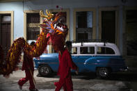 Dancers from the Cuban Wushu Association return home after perform during the ceremony to welcome the Chinese New Year in Havana, Cuba, Friday, Jan. 24, 2020. Cuba's small Chinese community celebrated the Lunar New year Friday night, ushering in the "Year of the Rat" with a colorful parade, brightly lit lanterns and a dragon wending its way through the narrow streets of Chinatown. (AP Photo/Ramon Espinosa)