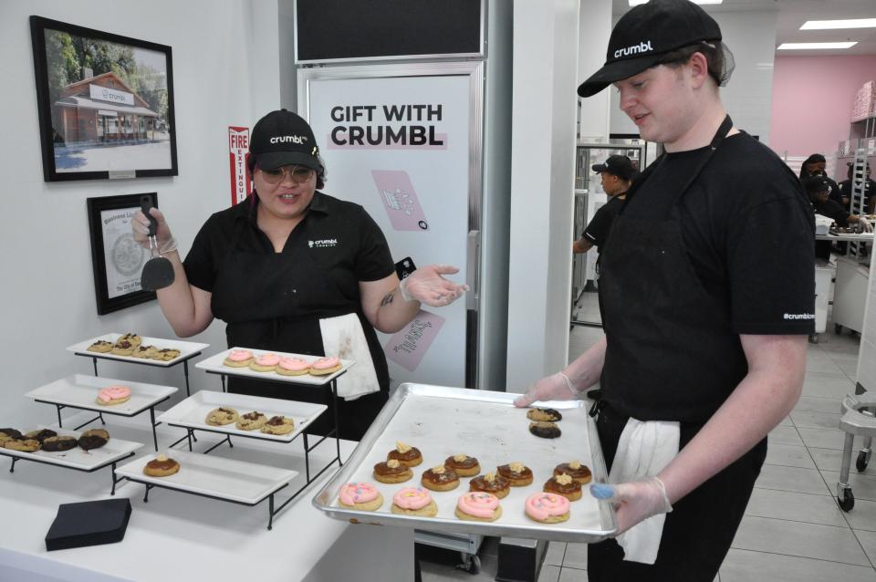 From left, Gabi Ramos and Grayson Lewis serve cookies during the March 20 sneak preview of the new Crumbl Cookies in Dover, 50 N. DuPont Highway (Route 13), in the Capital Station shopping center behind Aldi and Red Robin.