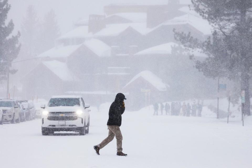 PHOTO: A person crosses a snow-covered road in Mammoth Lakes, Calif., on March 1, 2024.  (David Swanson/AFP via Getty Images)