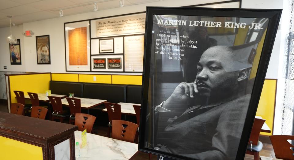 A framed Martin Luther King Jr. portrait is held by an Afra Grill staff member at their Morse Road restaurant.