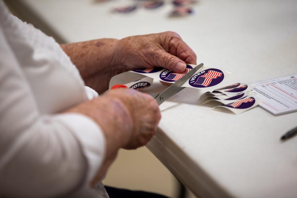 I Voted stickers are cut for voters as they head to the polls for the primary election Tuesday, Aug. 2, 2022, at Rose Park Reformed Church in Holland. 