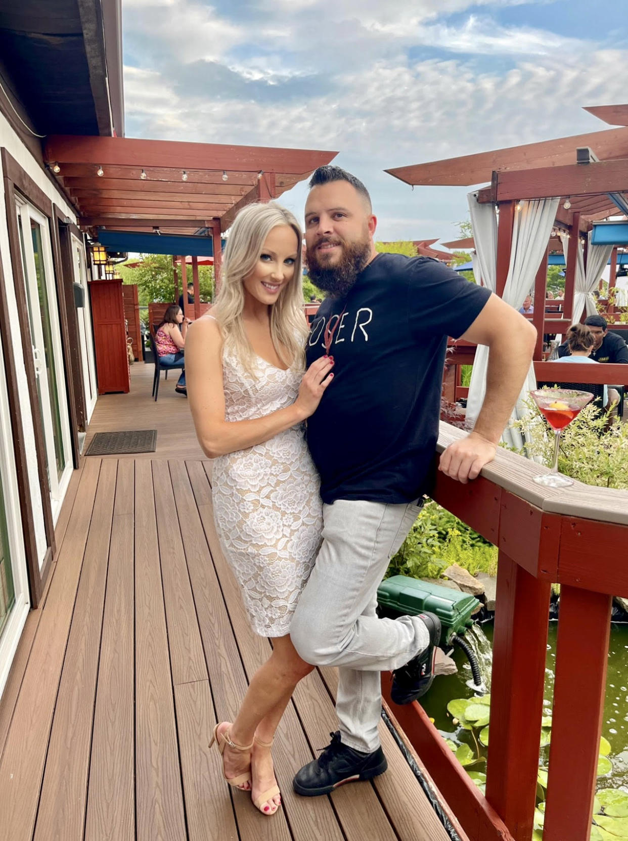 Woman and man, who are married, stand close together and are smiling