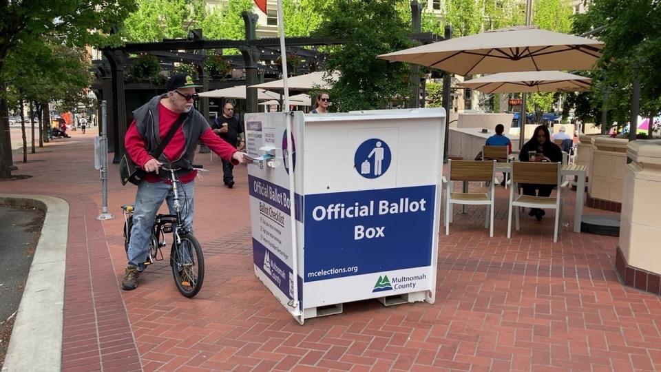 A voter drops off a ballot at a box in Pioneer Courthouse Square in Portland, Ore., Tuesday, May, 17, 2022. The state is holding its primary elections. (AP Photo/Gillian Flaccus)