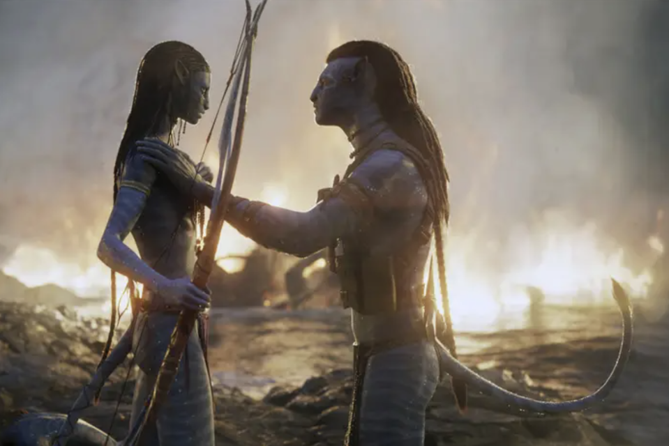 two tall blue na'vi ppl from avatar face each other at sunrise