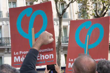 A protestor raises his fist in front of boards of the "France Insoumise" (France Unbowed) party during a demonstration against the government's labour reforms in Paris, France, September 23, 2017. REUTERS/Philippe Wojazer