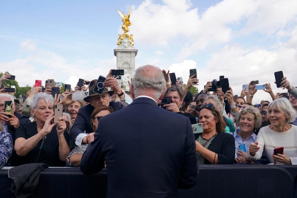 El Rey saluda a los simpatizantes a su paso por las puertas del Palacio de Buckingham el viernes (PA)