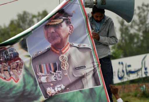 Pakistani demonstrators fix a poster of army Chief General Ashfaq Parvez Kayani at a gathering in support of army and intelligence agency ISI in Islamabad. Pakistan said Thursday it would review counter-terrorism cooperation with the United States as it comes under growing domestic pressure to punish Washington for the Osama bin Laden raid