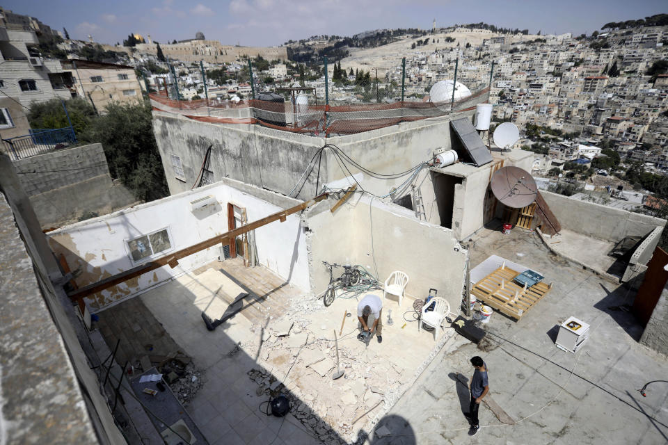 In this Monday, Sept. 9, 2019 photo, Palestinian Jamil Masalmeh uses a power tool to destroy an apartment he had added to his home years earlier, in the Silwan neighborhood of east Jerusalem. When he failed to secure a permit, Israeli municipal authorities gave him the option of destroying it himself or paying more than $20,000 for the city to demolish it. New data shows a spike in Jewish settlement construction in Israeli-annexed east Jerusalem since President Donald Trump took office and a huge, decades-old gap in the number of building permits granted to Jewish and Palestinian residents. (AP Photo/Mahmoud Illean)