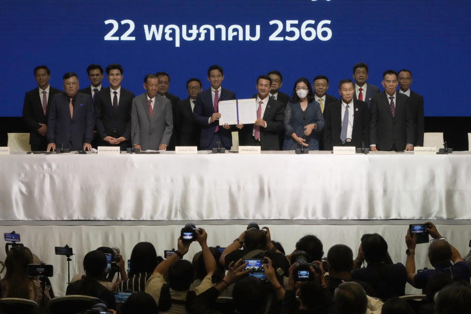 Leader of Move Forward Party Pita Limjaroenrat, center left, and Leader of Pheu Thai party Chonlanan Srikaew, center right, hold a memorandum of understanding on attempt to form a coalition government between Move Forward Party and other parties during a news conference in Bangkok, Thailand, Monday, May 22, 2023. Move Forward won the most seats in the May 14 election, and it has formed a coalition that seeks to become the government when Parliament selects a prime minister in July. (AP Photo/Sakchai Lalit)