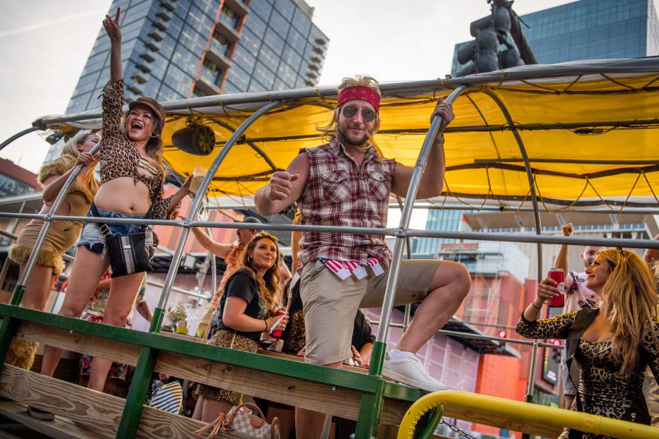 Riders wave from a party bus on Lower Broadway in Nashville.