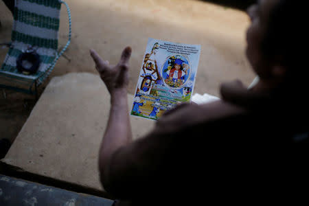 Tulio Medina holds a photo of his daughter Eliannys Vivas, who died from diphtheria, at the front porch of his home in Pariaguan, Venezuela January 26, 2017. REUTERS/Marco Bello