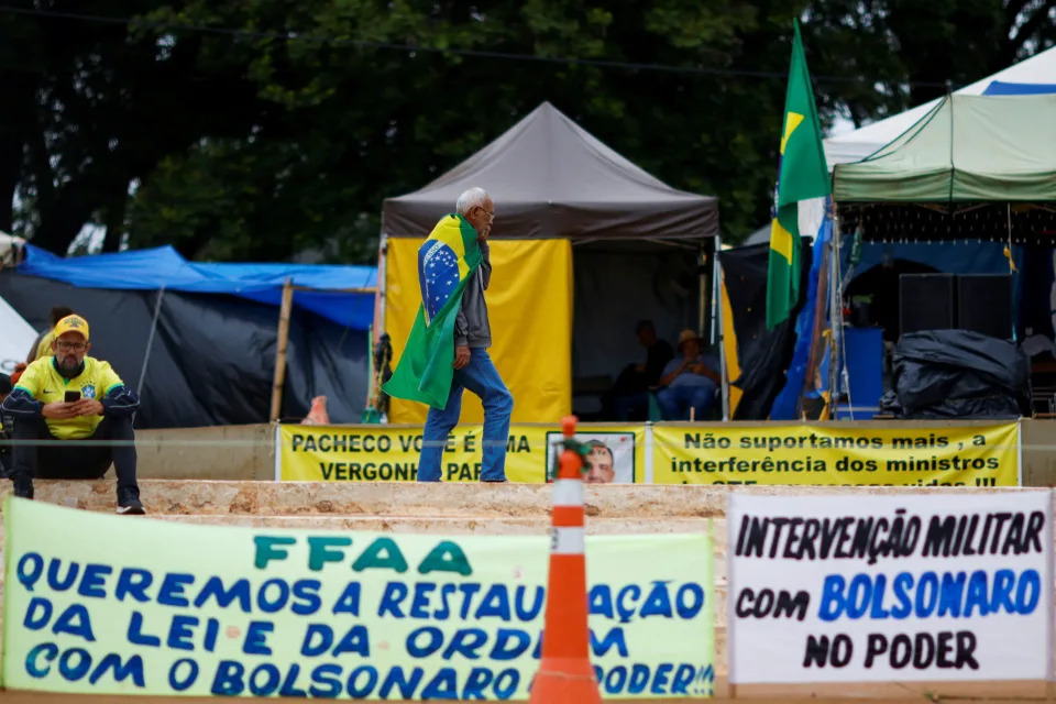 A supporter of Brazil&#39;s President Jair Bolsonaro walks in front of tents in a camp during a protest against President-elect Luiz Inacio Lula da Silva, who won a third term following the presidential election run-off, at the Army Headquarters in Brasilia, Brazil, December 27, 2022. REUTERS/Adriano Machado