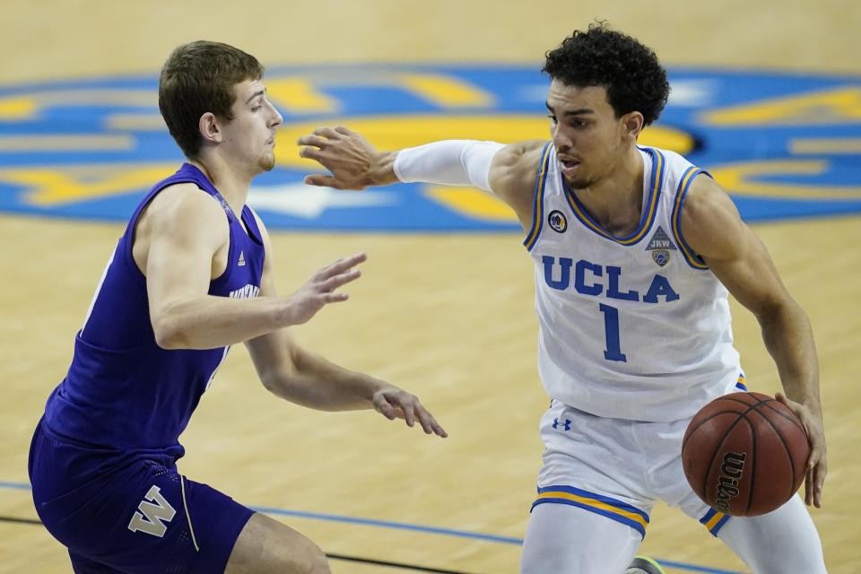 Washington guard Erik Stevenson, left, defends against UCLA guard Jules Bernard (1) during the second half of an NCAA college basketball game Saturday, Jan. 16, 2021, in Los Angeles. (AP Photo/Ashley Landis)