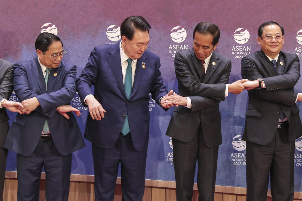 From left to right, Vietnam's Prime Minister Pham Minh Chinh, South Korean President Yoon Suk Yeol, Indonesian President Joko Widodo and Laos' Prime Minister Sonexay Siphandone hold hands for a family photo during the ASEAN-South Korea Summit in Jakarta, Indonesia, Wednesday, Sept. 6, 2023. (Bagus Indahono/Pool Photo via AP)