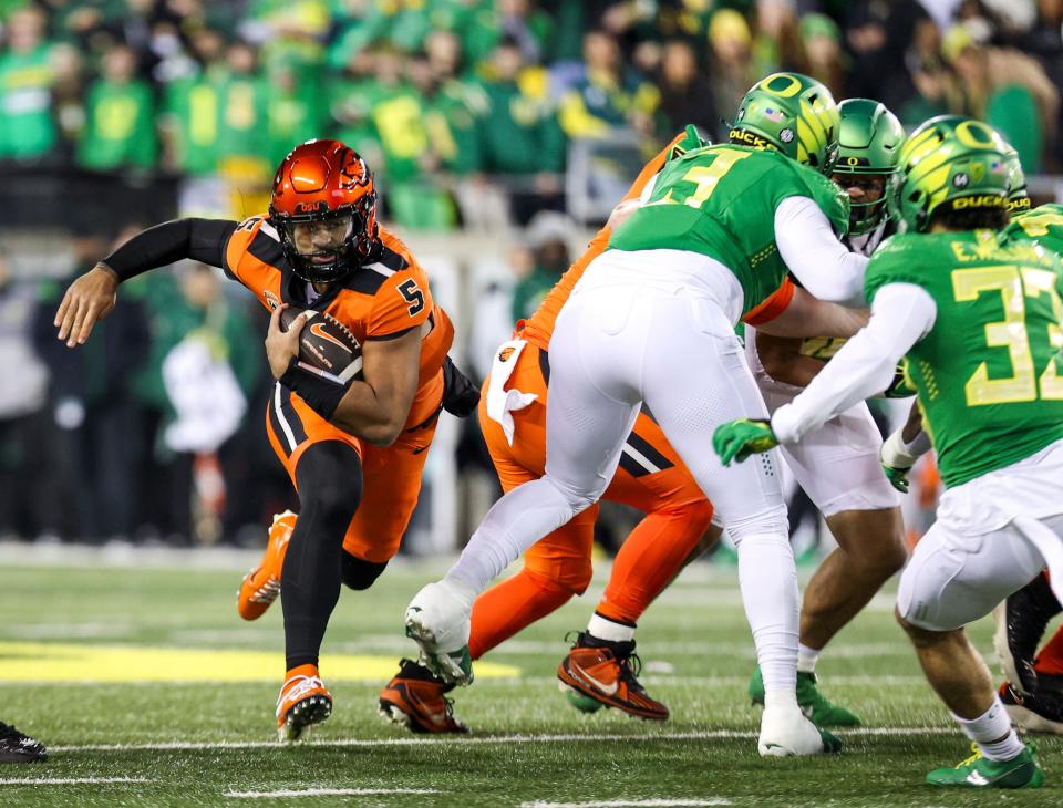 Oregon State Beavers quarterback DJ Uiagalelei holds on to the ball during the first half of the annual rivalry game against the Oregon Ducks on Friday, Nov. 24, 2023 at Autzen Stadium in Eugene, Ore.