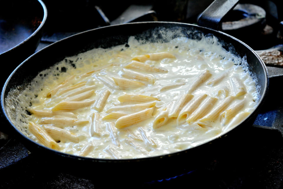 Penne in cheese sauce in a skillet.