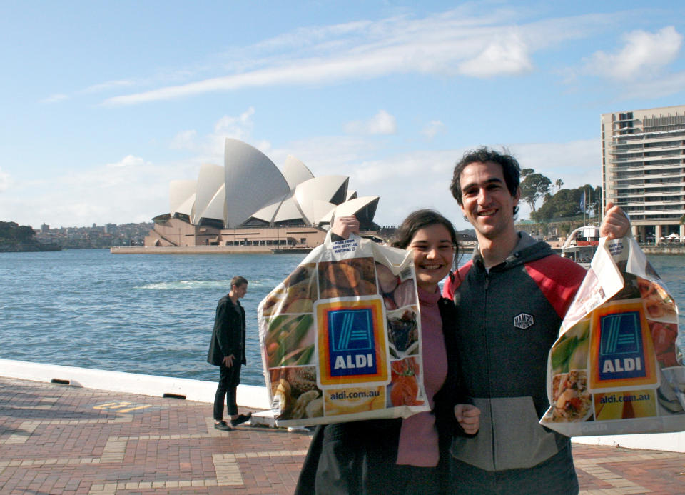 Aldi customers Hannah Walker (26) and Mike Weekes (29) stand at the Opera House in Sydney, Australia, 19 July 2015.