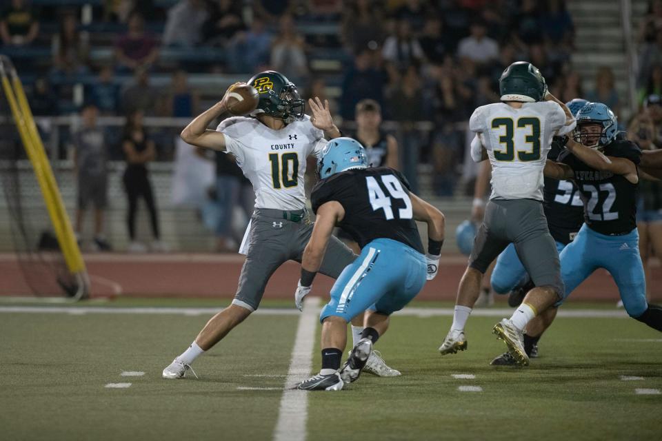 Pueblo County's Cohen Glenn pulls back to pass with pressure coming from Pueblo West's Johnathan Forsythe during the 20th annual Pigskin Classic game at the Colorado State University Pueblo ThunderBowl on Friday, September 2, 2022.