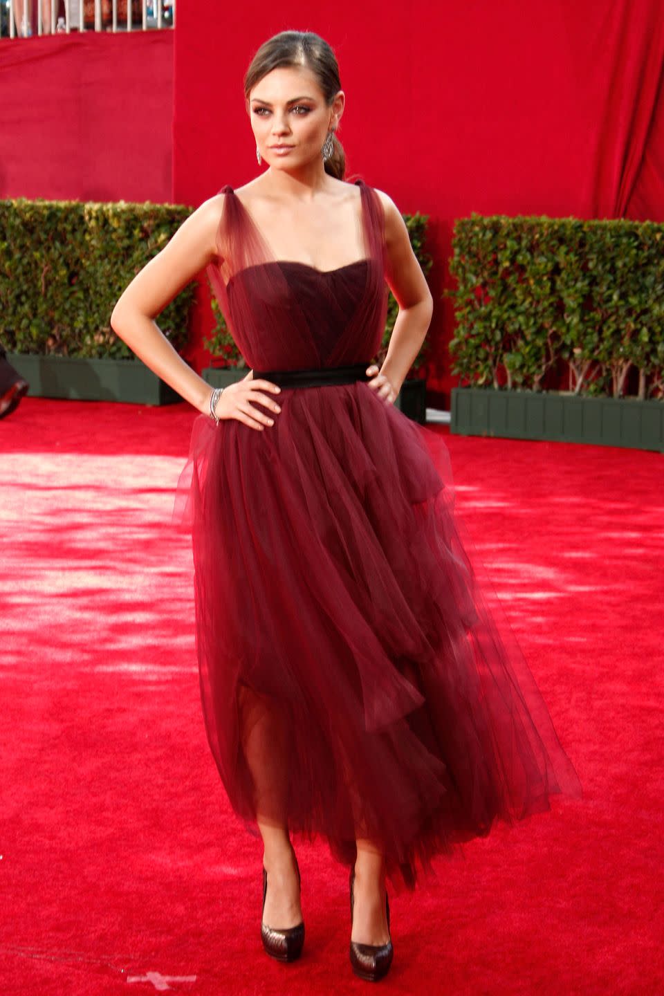 <p>A dreamy tulle midi dress with tie sleeves and a cinched waist made for a beautiful red carpet outfit. Mila complemented her look with pumps and statement earrings. </p>