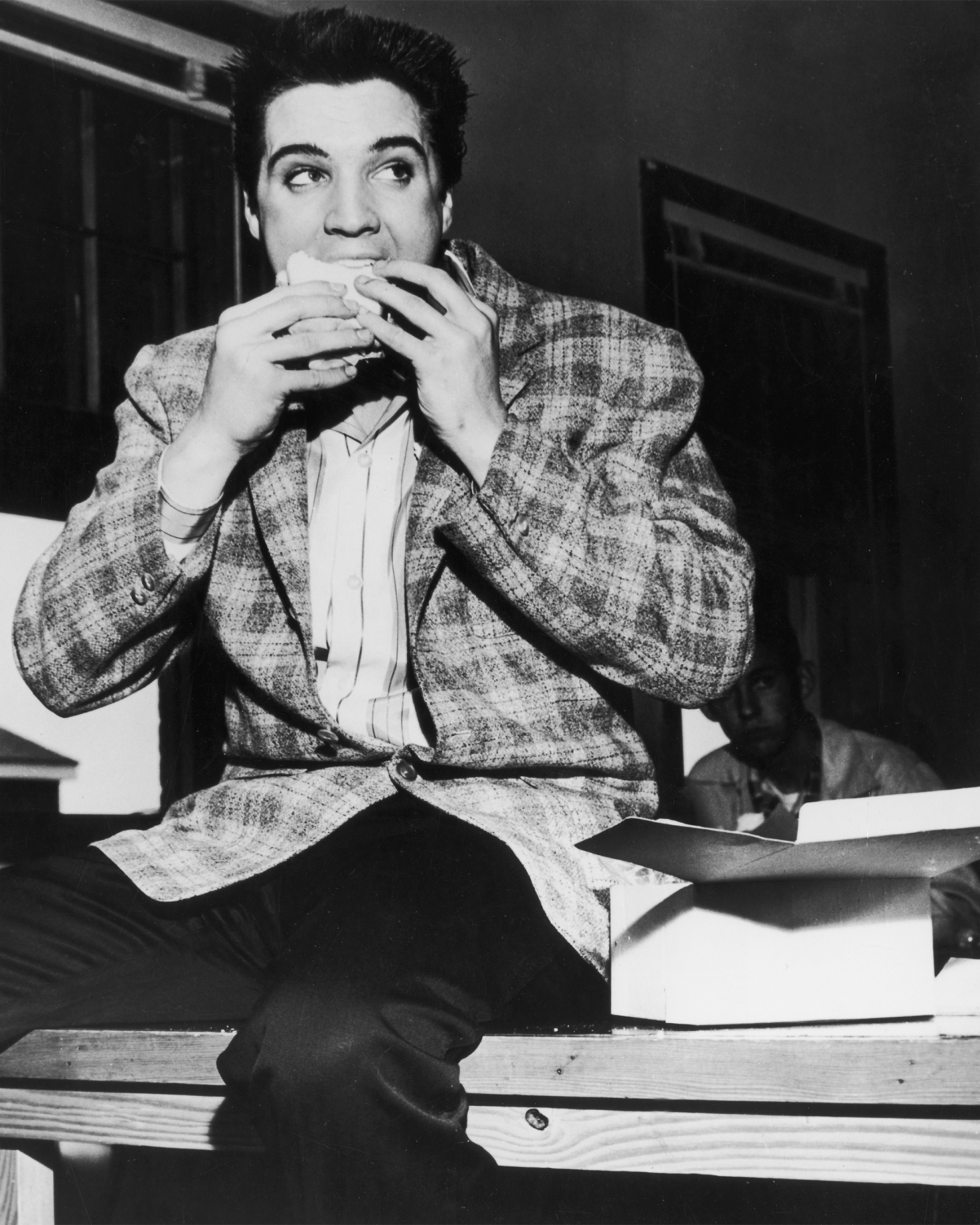 Elvis Presley eating a sandwich