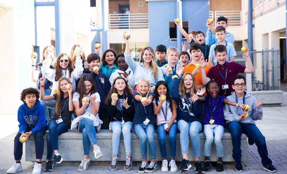 Sixth-grade teacher Mishelle Levine smiles with her class after receiving a Golden Apple award from Champions for Learning on Feb. 17 at Oakridge Middle in Naples. The education foundation made a surprise visit to six schools to recognize teachers and their classroom best practices.