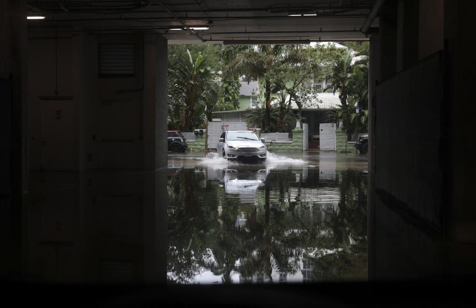 A car pulls into a parking garage on 25th street during a rain storm, Wednesday, April 12, 2023, in Miami. A torrential storm bought heavy showers, gusty winds and thunderstorms to South Florida on Wednesday and prompted the closure of Fort Lauderdale-Hollywood International Airport and the suspension of high-speed commuter rail service in the region.(Alie Skowronski/Miami Herald via AP)
