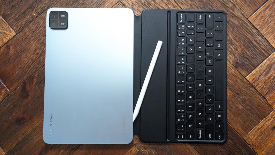 The Xiaomi Pad 6 in light blue with its accessories on a wooden table.