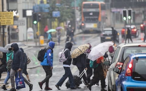 Commuters travel during heavy downpours in Bristol - Credit: SWNS