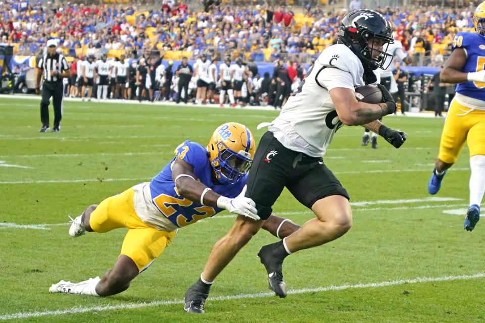 Cincinnati tight end Payten Singletary, right, escapes a tackle attempt by Pittsburgh linebacker Solomon DeShields (23) for a touchdown during the first half of an NCAA college football game in Pittsburgh on Saturday, Sept. 9, 2023. (AP Photo/Gene J. Puskar)