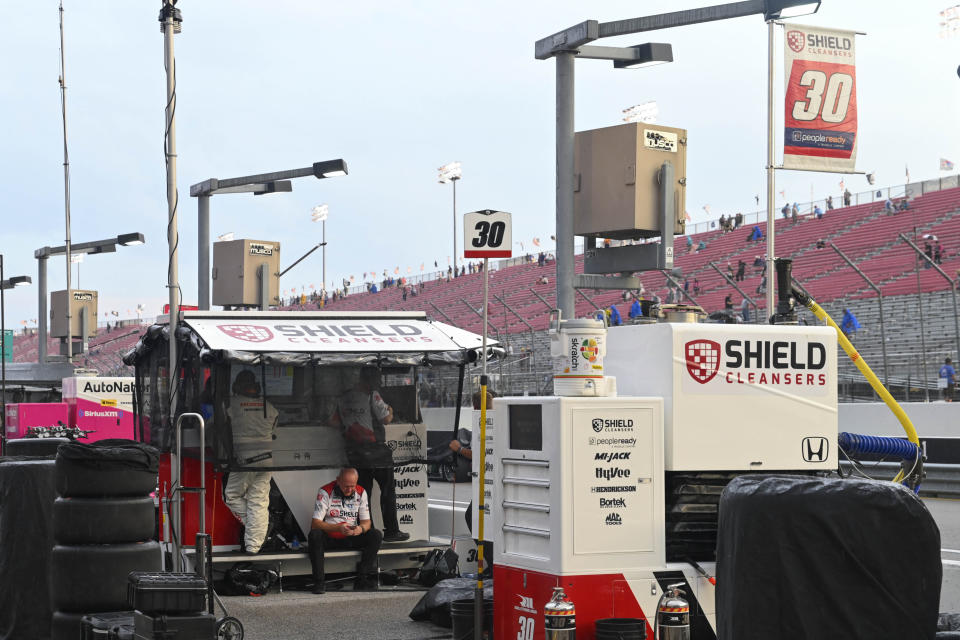 Scott McLaughlin (3) takes cover during a stop in the race due to rain in an IndyCar auto race at World Wide Technology Raceway, Saturday, Aug. 20, 2022, in Madison, Ill. (AP Photo/Joe Puetz)