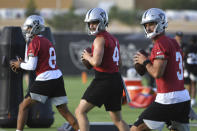 Las Vegas Raiders quarterbacks Marcus Mariota (8), Derek Carr (4) and Nathan Peterman perform drills during an NFL football practice Wednesday, July 28, 2021, in Henderson. (AP Photo/David Becker)