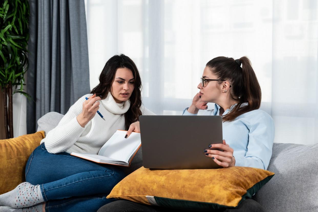Two young women couple making their online business for shopping booking and restaurant reservation as internet app service. Lesbian girls working on plans and ideas for their new small company.