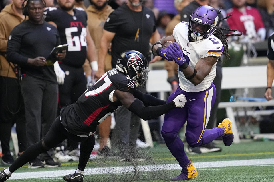 Minnesota Vikings running back Alexander Mattison (2) runs after a catch past Atlanta Falcons safety Richie Grant (27) during the first half of an NFL football game, Sunday, Nov. 5, 2023, in Atlanta. (AP Photo/Mike Stewart)