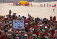 Surf lifesavers can be seen behind protesters participating in a national Day of Action against the Indian mining company Adani's planned coal mine project in north-east Australia, at Sydney's Bondi Beach in Australia, October 7, 2017. REUTERS/David Gray