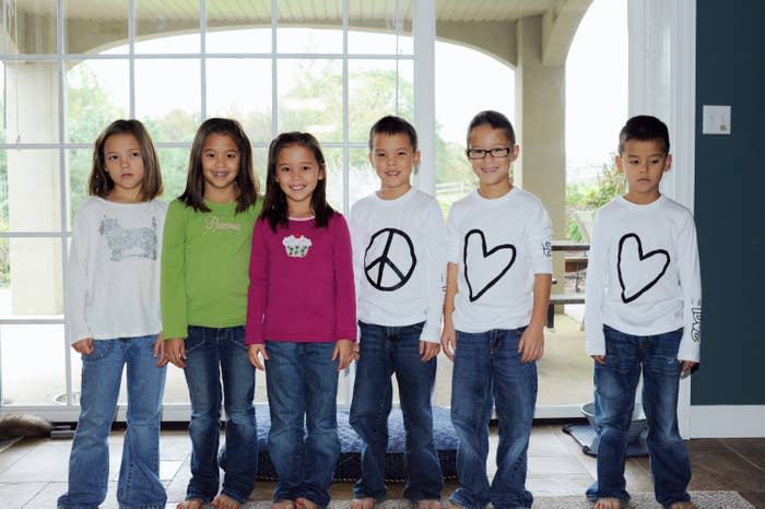 The sextuplets pose together as kids