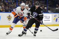 Tampa Bay Lightning center Anthony Cirelli (71) tries to controdl a bouncing puck in front of New York Islanders center Brock Nelson (29) during the second period of an NHL hockey game Saturday, March 30, 2024, in Tampa, Fla. (AP Photo/Chris O'Meara)