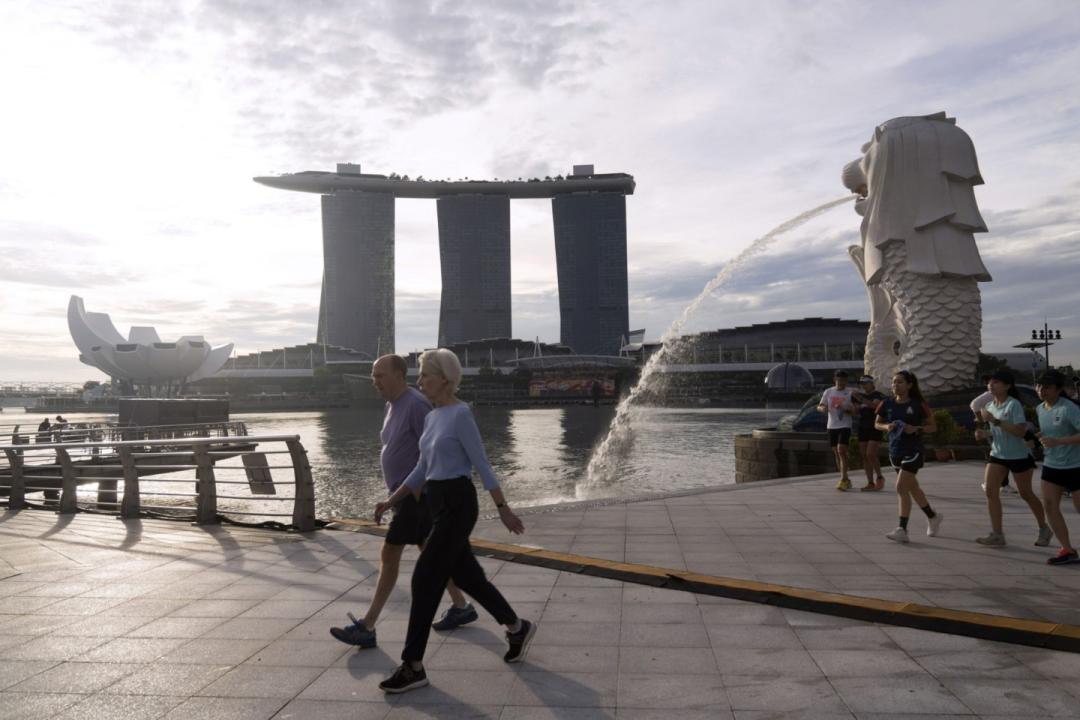 People exercise by the Merlion Park and Marina Bay Sands in Singapore, on Saturday, Oct. 8, 2022. Singapore is scheduled to announce its third quarter advanced gross domestic product (GDP) estimate on Oct 10, 2022.