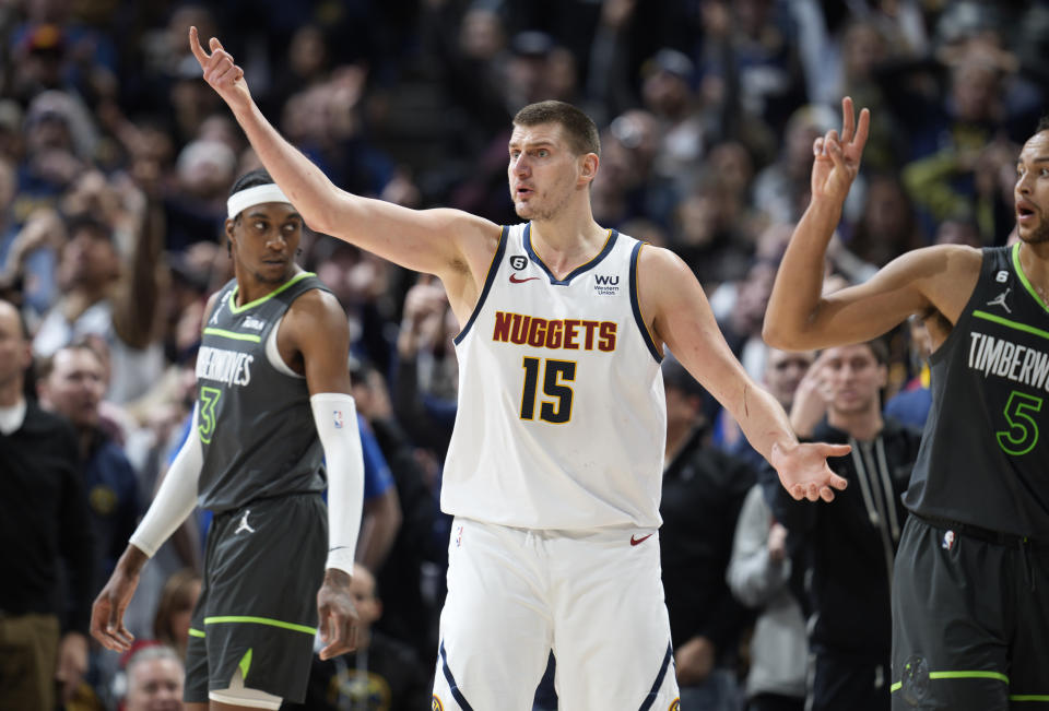 Denver Nuggets center Nikola Jokic (15) looks to referees for a call, near Minnesota Timberwolves forwards Kyle Anderson, right, and Jaden McDaniels during the second half of an NBA basketball game Wednesday, Jan. 18, 2023, in Denver. (AP Photo/David Zalubowski)