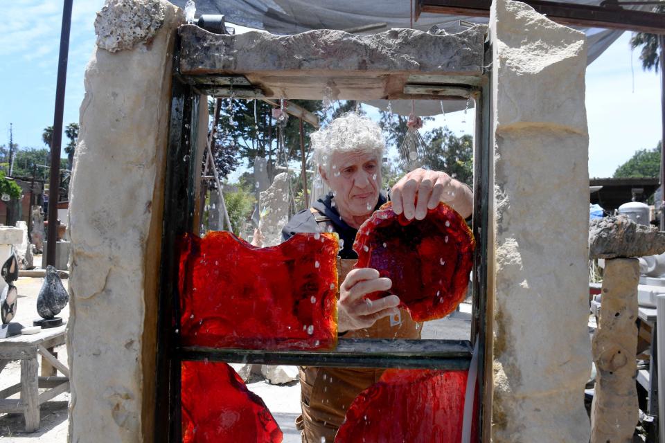 Greg Kailian, a stone sculptor at Art City in Ventura, works on a stone and glass water fountain on Friday, June 17, 2022. The Art City property was recently sold.