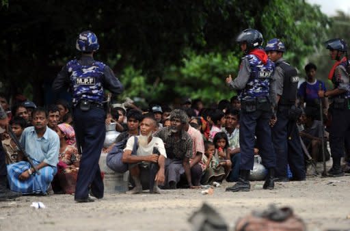 Policemen guard Muslim residents who have evacuated their homes amid ongoing violence in Sittwe, capital of Myanmar's western state of Rakhine, on June 12. Dozens of people have been killed in a surge in sectarian violence in the area, an official said on June 12, as international pressure grew for an end to the bloodshed