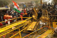 NEW DELHI, INDIA - JANUARY 26 : Indian Farmers attempt to break a barricade farmers who marched to the capital during India's Republic Day celebrations in New Delhi on India January 26, 2021, The thousands of farmers drove a convoy of tractors into the Indian capital as the nation celebrated Republic Day on Tuesday in the backdrop of agricultural protests that have grown into a rebellion and rattled the government. (Photo by Imtiyaz Khan/Anadolu Agency via Getty Images)