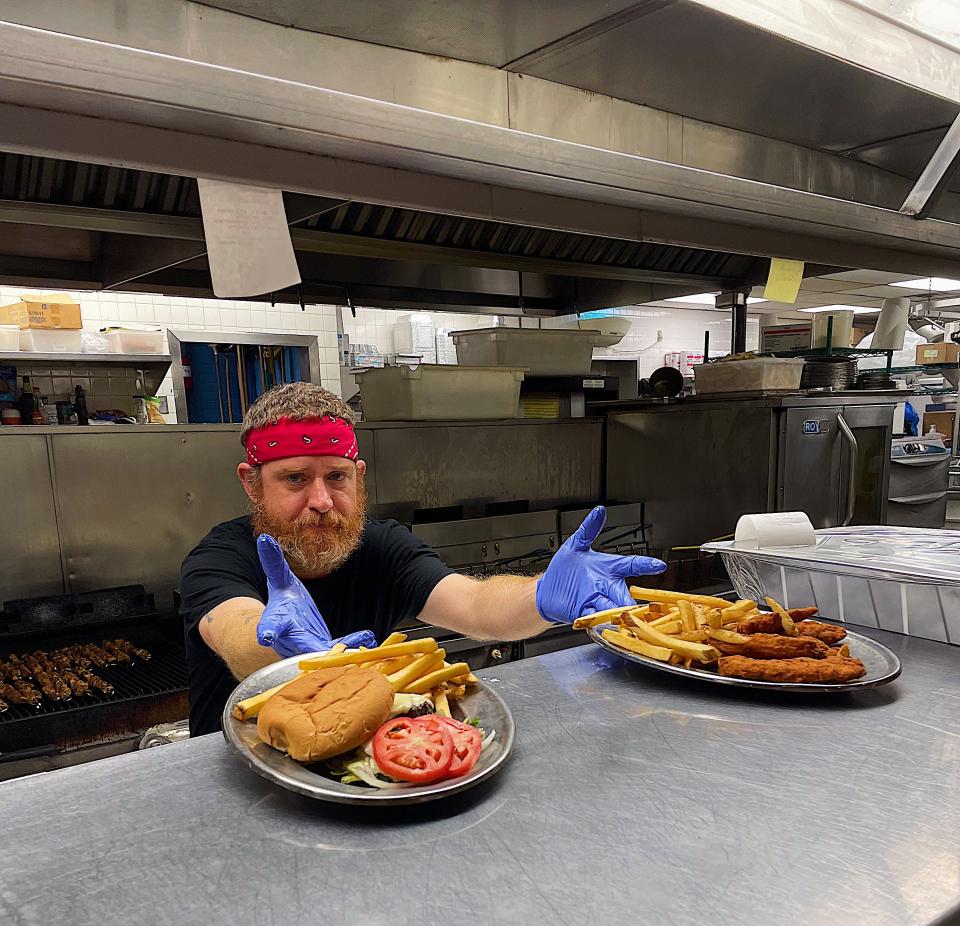 Order up! Symeon's line cook Mike Calhoun presents plates of sandwiches, chicken tenders and golden brown fries.