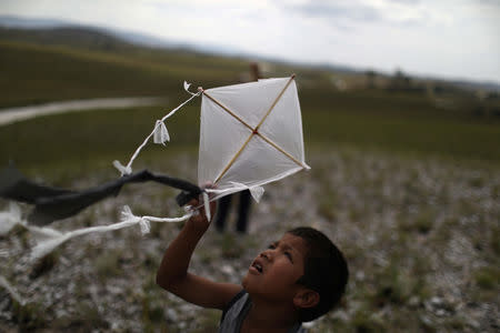 FILE PHOTO: A Venezuelan indigenous boy of Pemon tribe flies a kite at the Brazilian indigenous village Tarau Paru in the border city of Pacaraima, Brazil April 12, 2019. REUTERS/Pilar Olivares