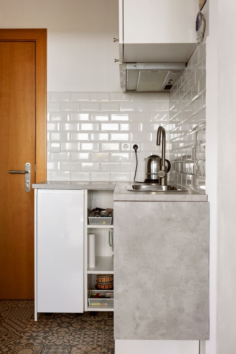 Corner kitchen space in neutral toned room.