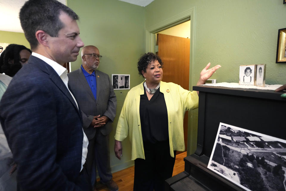 U.S. Transportation Secretary Pete Buttigieg, left, U.S. Rep. Bennie Thompson, D-Miss., center, listen as Reena Evers-Everette, points out photographs of her five-year-old self and her older brother Darrell Kenyatta Evers, then six, on top of her mother's piano, as a group of dignitaries toured the home of assassinated civil rights leader Medgar Evers, Friday, June 21, 2024, in Jackson, Miss. The house, the Medgar and Myrlie Evers National Monument, was one of the stops Buttigieg made as he spent Thursday and Friday in Mississippi, promoting projects that will be helped or will be receiving money from a federal infrastructure act. (AP Photo/Rogelio V. Solis, Pool)